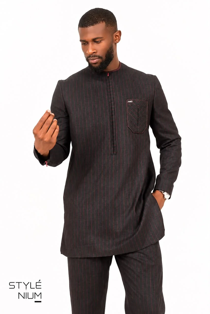 Homme portant un ensemble tunique et pantalon noir à fines rayures bordeaux, col rond et poche poitrine surpiquée, création AMG STYLENIUM