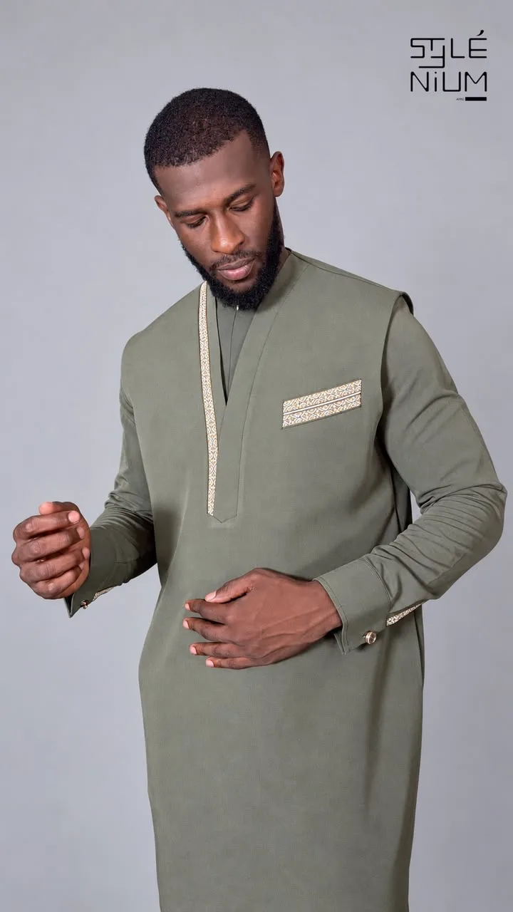 Homme portant une tunique longue olive avec galons dorés au plastron, à la poche et aux poignets, création AMG STYLENIUM